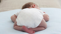 Bildet viser nyfødt baby som ligger på magen
