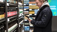 mann handler på systembolaget