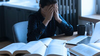Student som hviler ansiktet i hendene. Bildet viser en student som hviler ansiktet i hendene.