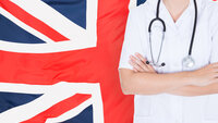 Bildet viser et britisk flagg i bakgrunnen og overkroppen til en person i hvit uniform Bildet viser et britisk flagg i bakgrunnen og overkroppen til en person i hvit uniform