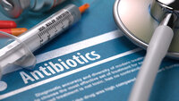 Bilde av sprøyte og antibiotika som ligger på en bakgrunn hvor det står "antibiotika" Bilde av sprøyte og antibiotika som ligger på en bakgrunn hvor det står "antibiotika"