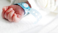 Bildet viser hånden til en nyfødt baby.