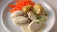 Bildet viser fiskeboller i hvit saus på en tallerken.