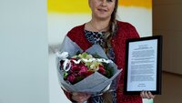 Bildet viser Målfrid J. Frahm Jensen med diplom og blomster.